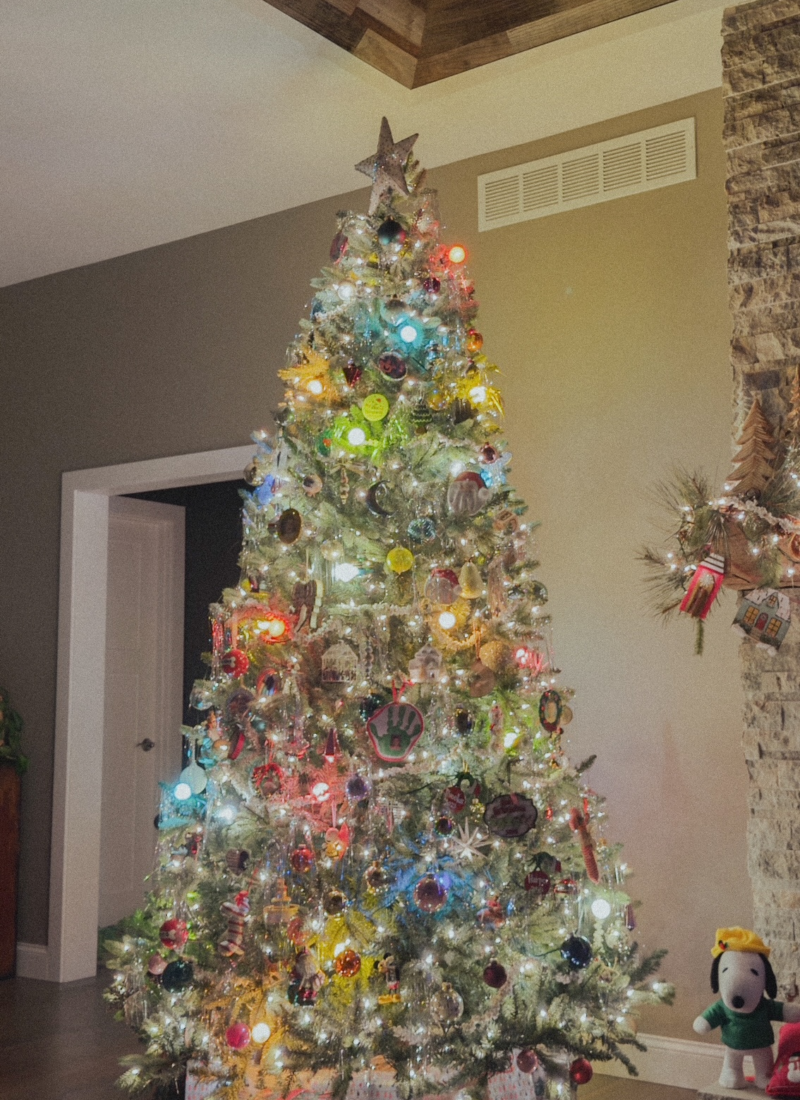 colorful, nostalgic christmas tree with large colorful bulbs, white lights, and a variety of collected ornaments.