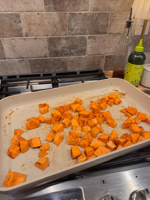 seasoned sweet potatoes in a roasting pan