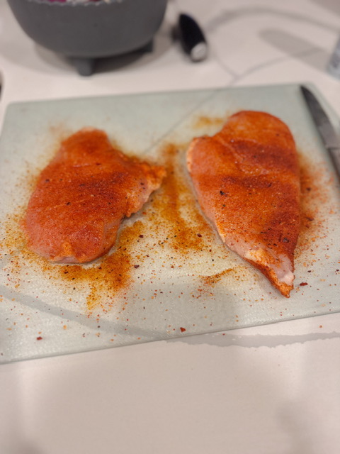 raw chicken breasts coated in seasoning