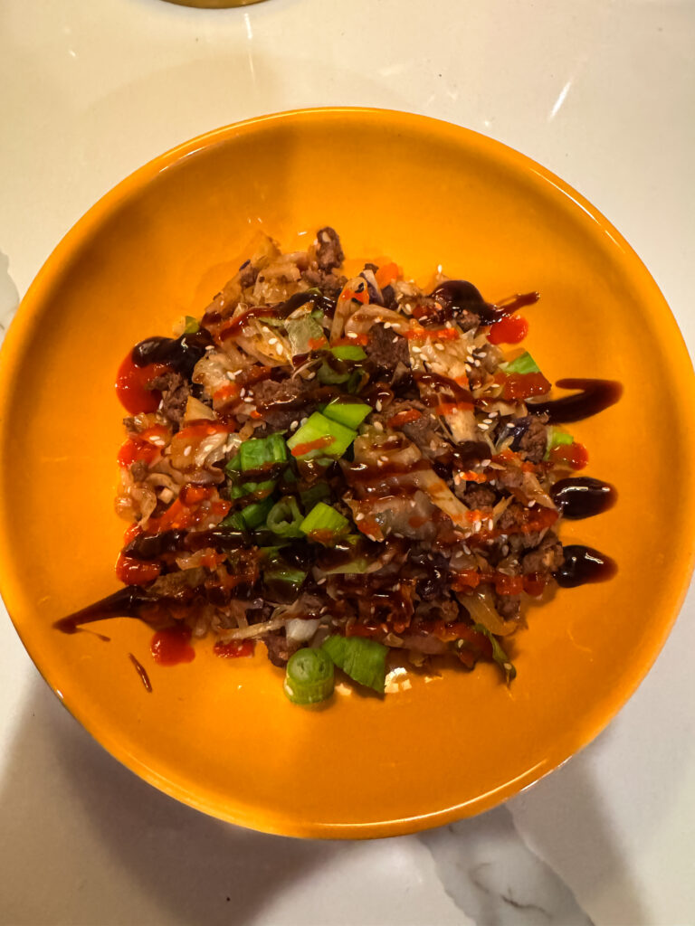 plated healthy egg roll bowl with sauces on top