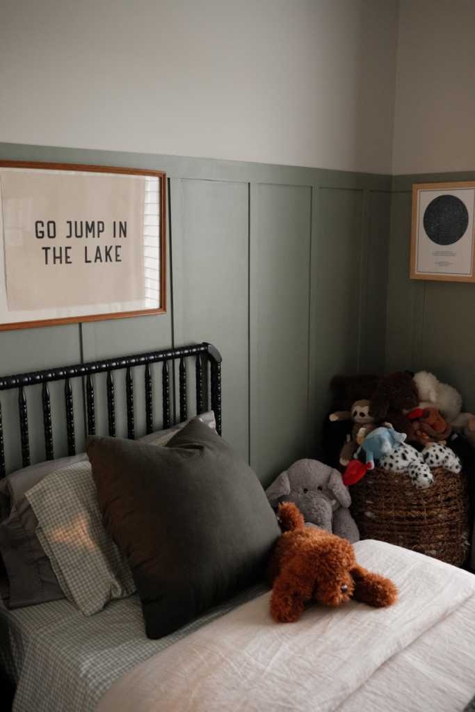 stuffed animals and bed in cozy vintage boys bedroom